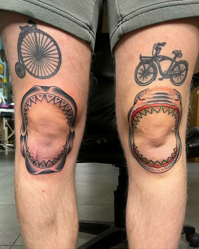 Unique knee tattoos featuring sharks and bicycles on both legs.