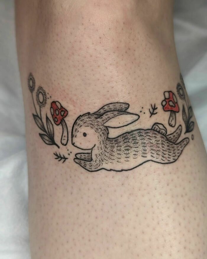 Rabbit and floral knee tattoo design featuring mushrooms and flowers.