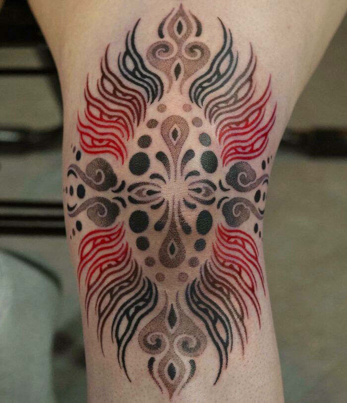 Abstract black and red knee tattoo 