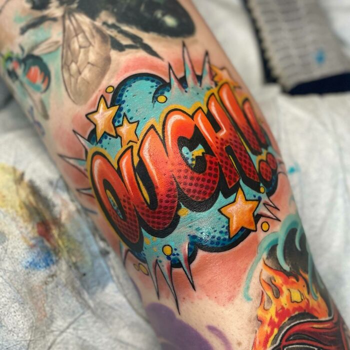 Comic "Ouch" saying on the knee with stars tattoo