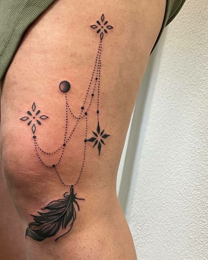 Star like symbols and feather tattoo 