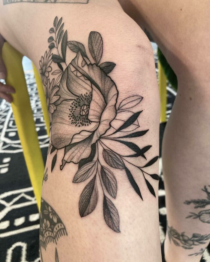 Floral knee tattoo design with intricate shading on a person's leg.
