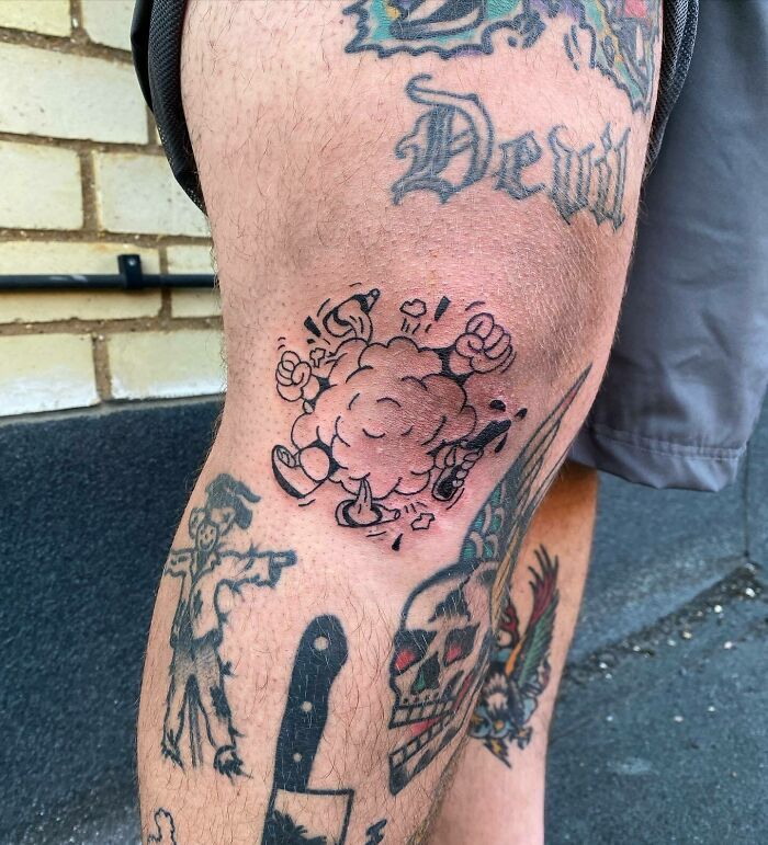 Knee tattoos with cartoon-style explosion and other intricate designs on the leg, creating a bold statement.