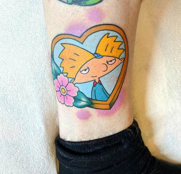 Hey Arnold with flower and heart shape leg tattoo