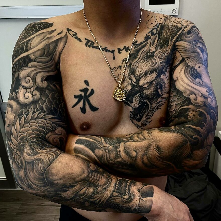 a dragon tattoo alongside tattoo of japanese kanji