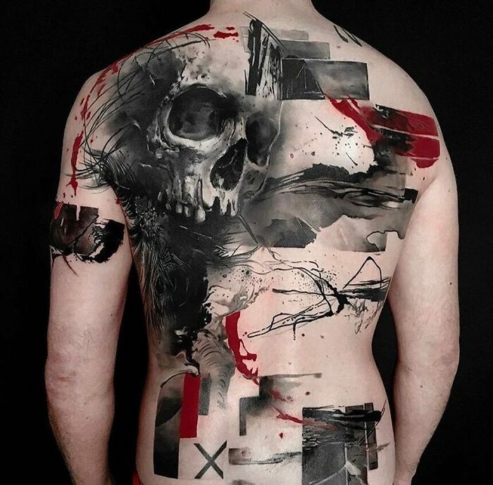 Back adorned with a Trash Polka tattoo, featuring a skull and abstract red and black elements.