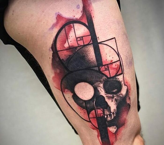 Trash Polka tattoo featuring a skull with geometric elements and red splashes.