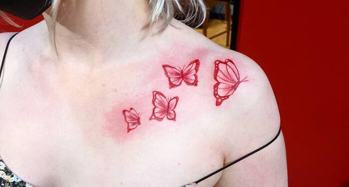 Red Ink Butterfly Collarbone Tattoo