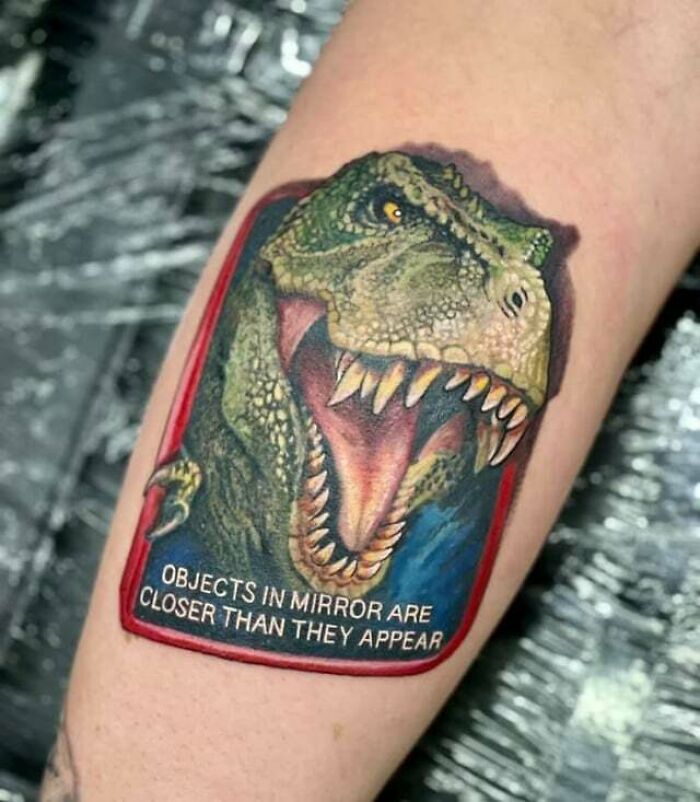 Jurassic Park green dinosaur arm tattoo