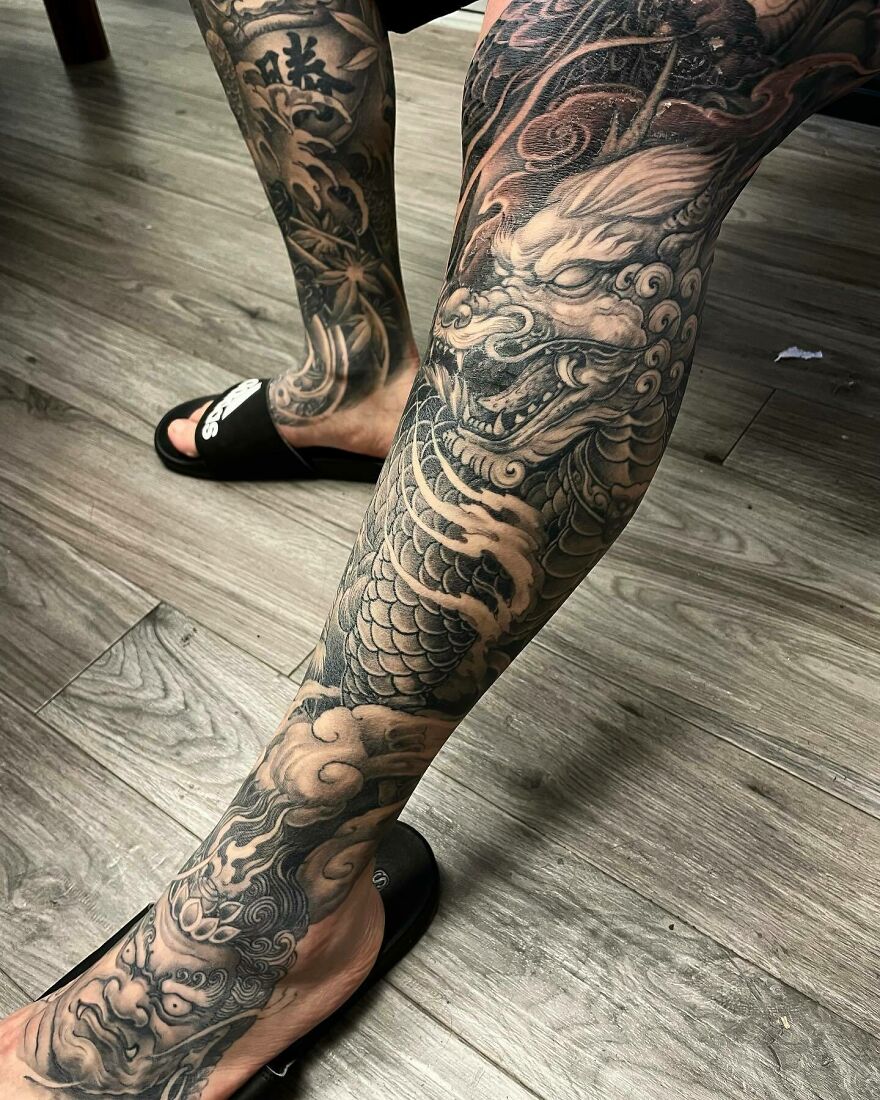 Tattoo Design Of A Dragon In Black Ink Covering The Entire Leg
