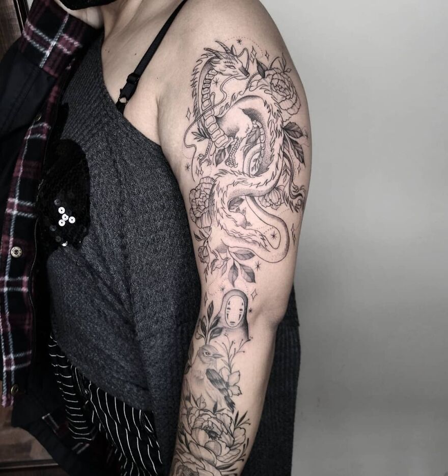 full sleeve tattoo of a haku dragon a bird and some flowers