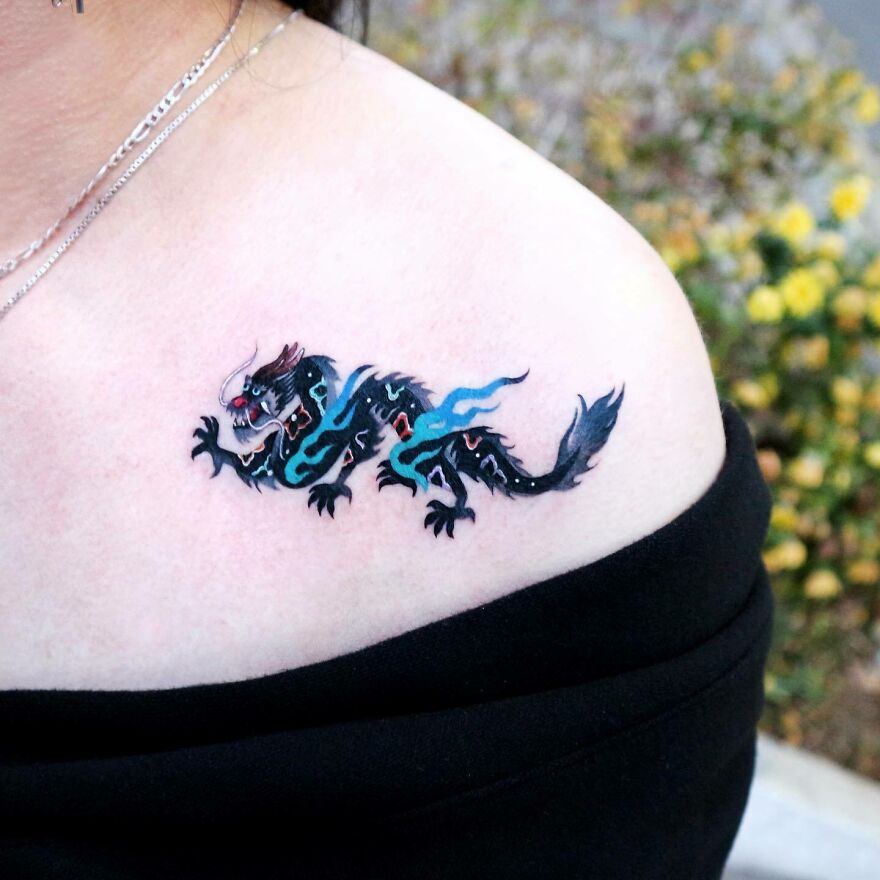 simple tattoo of a dragon on shoulder