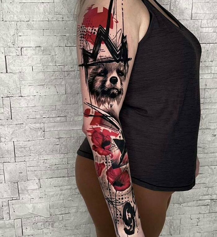 Person with a striking Trash Polka tattoo design, featuring red and black elements on their arm.