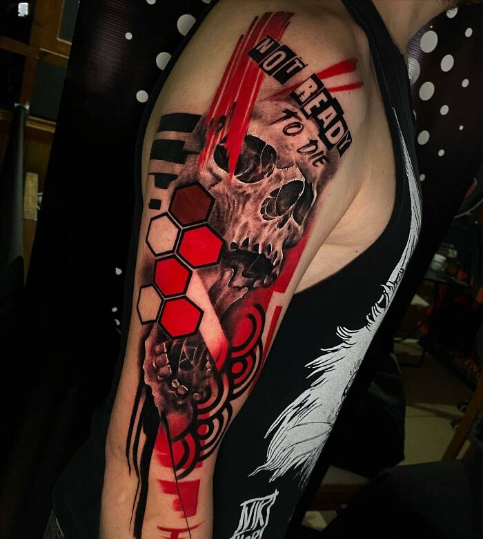 Trash Polka tattoo with skull, red accents, and text "Not ready to die" on upper arm.