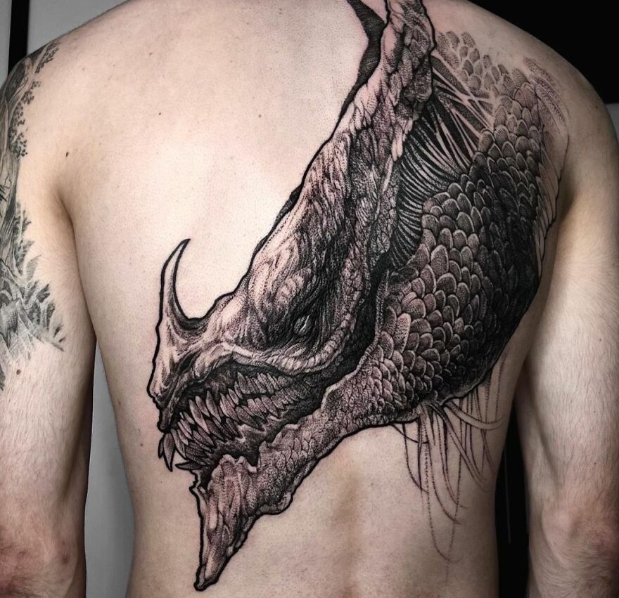 black ink tattoo of a magma dragon on the back