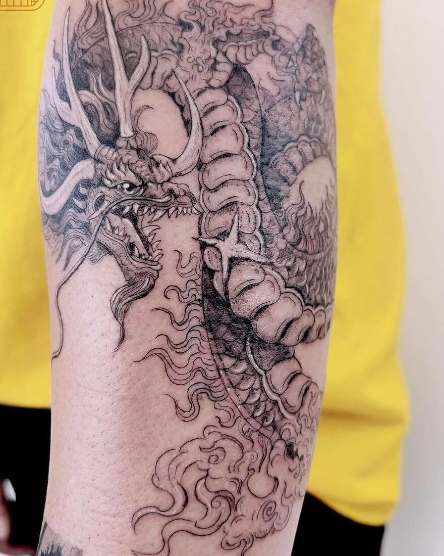 detailed tattoo of a dragon with horns