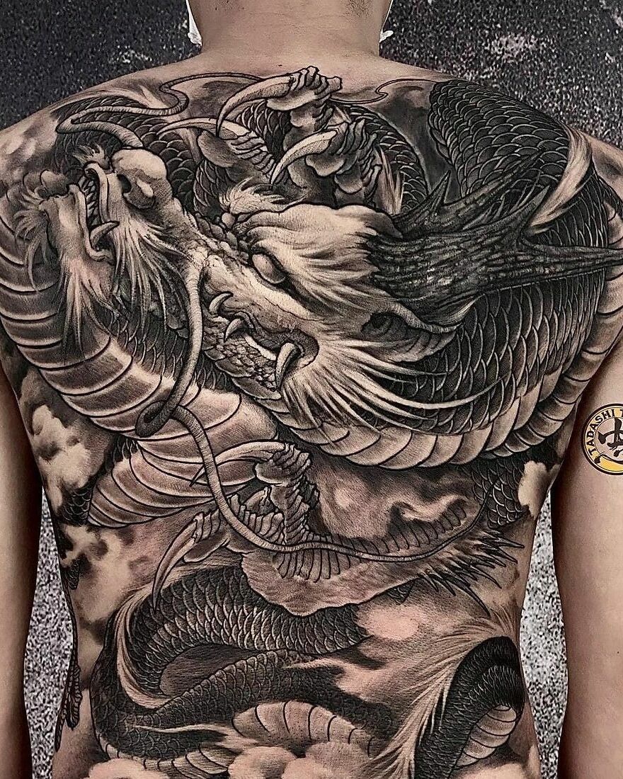 a black ink tattoo of a dragon on back