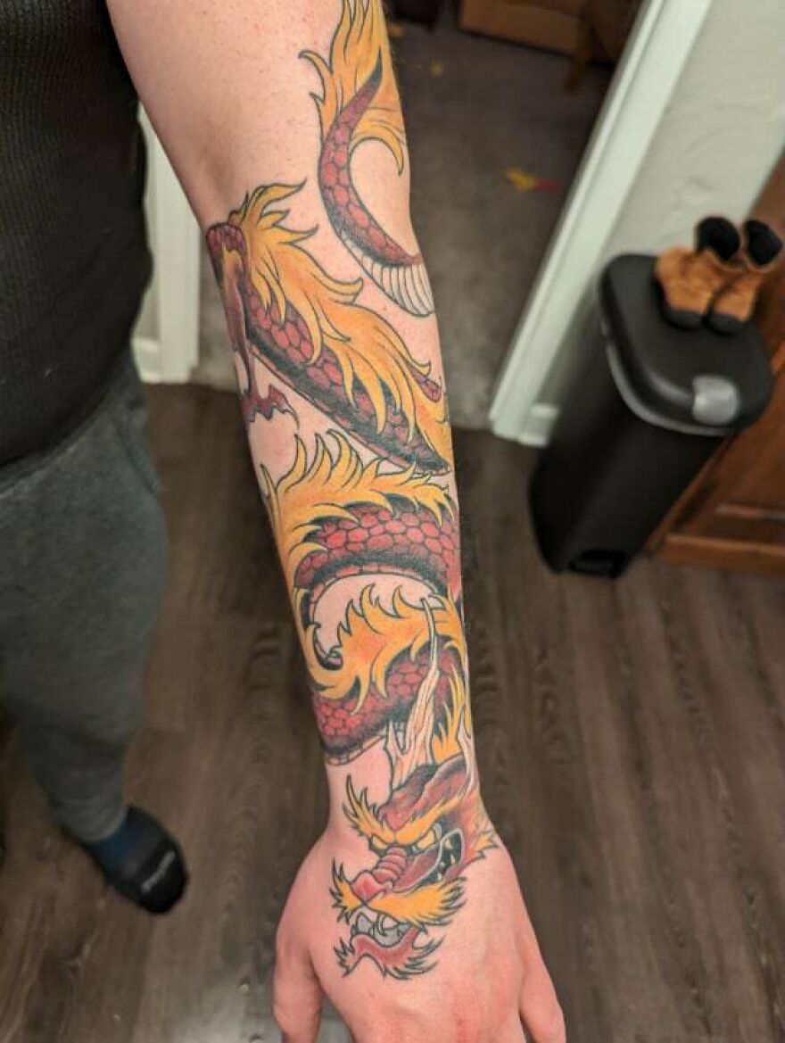 sleeve tattoo of a red dragon with yellow fur