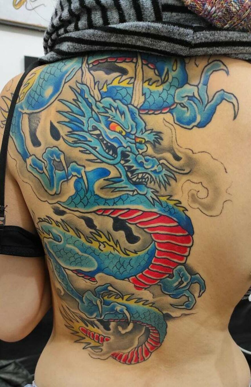 back tattoo of a blue colored dragon