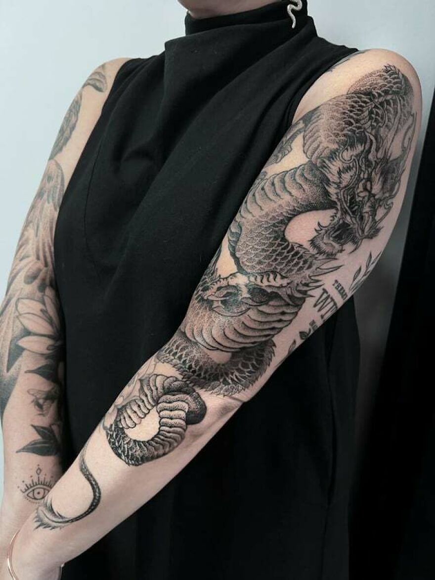 dragon in an aggressive stance sleeve tattoo
