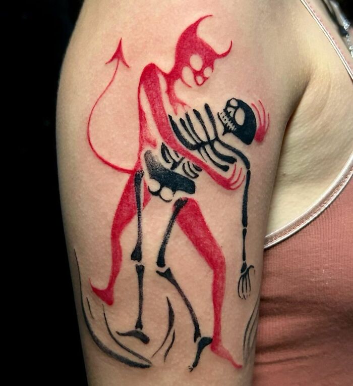 Red devil and black skeleton dance tattoo on arm