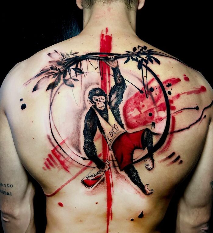 Monkey-themed Trash Polka tattoo on a man's back featuring bold red and black ink accents.