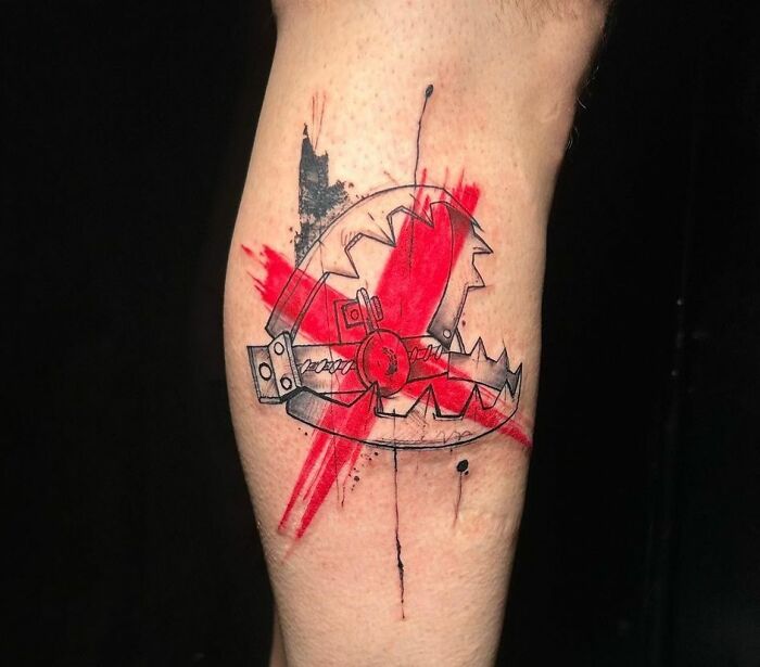 Trash Polka tattoo with jagged gears and red accents on skin.