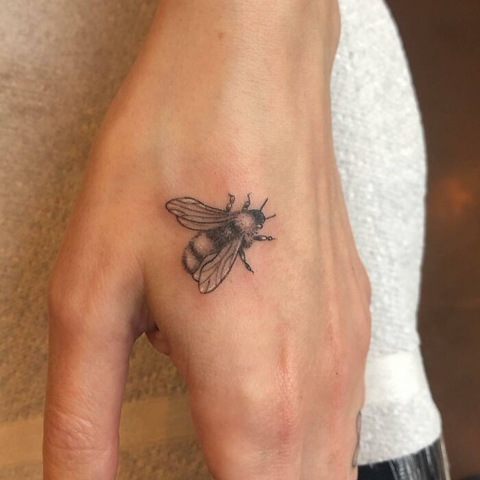 Tiny life size realistic bumble bee tattoo on the hand