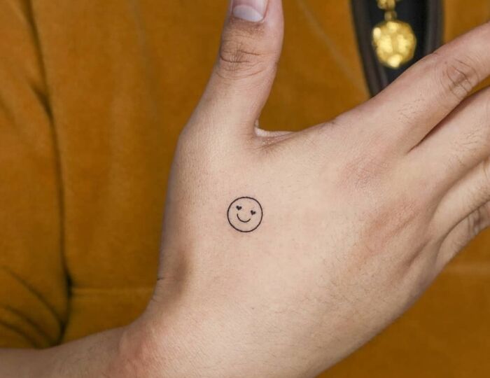 Smiley with heart eyes tattoo on hand