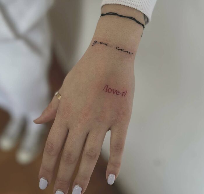 ‘Lover‘ red word tattoo on hand