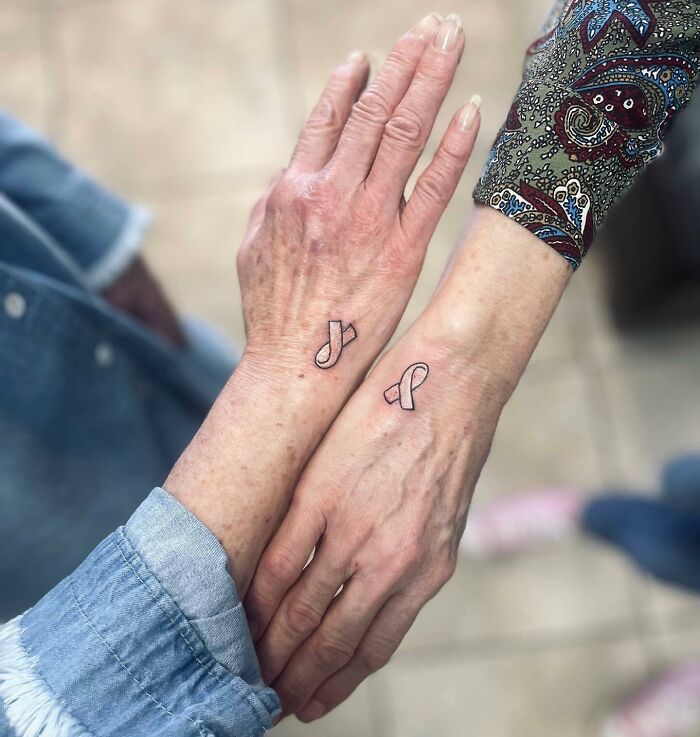 Lung cancer awareness tattoos on two women's hands