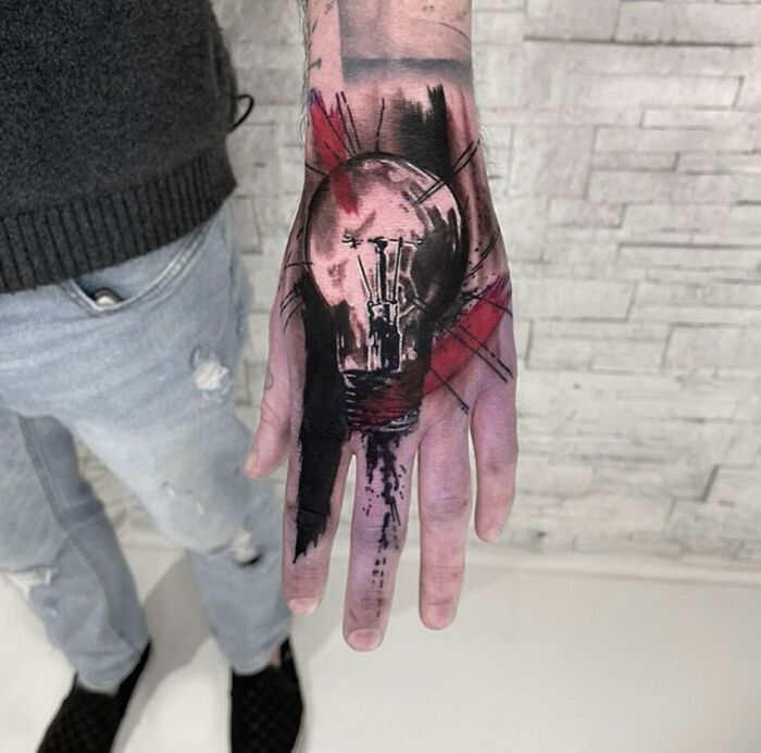 Black and red light bulb tattoo on hand