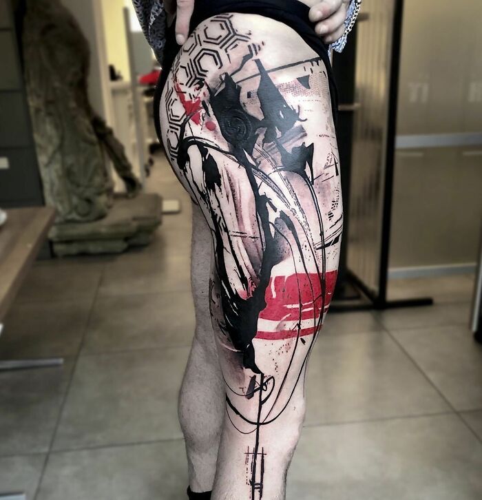 Abstract large red and black tattoo on leg
