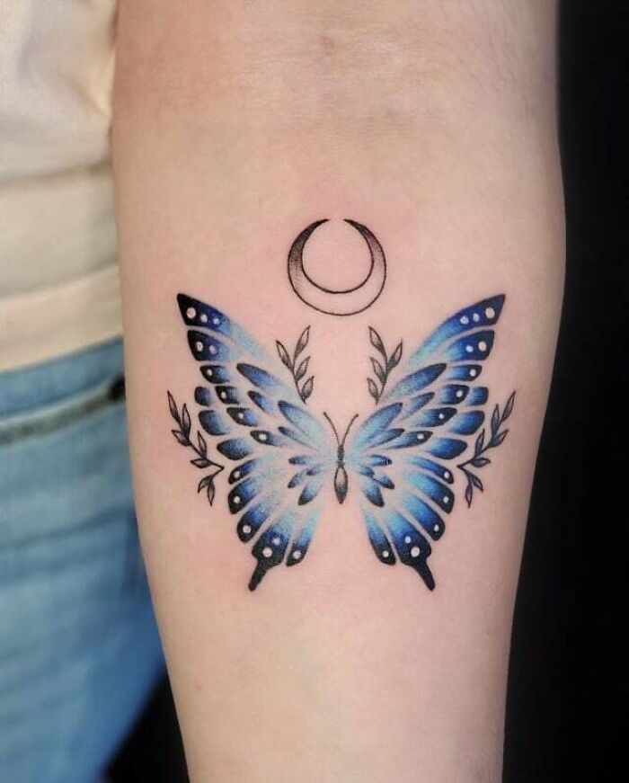 blue butterfly with moon arm tattoo