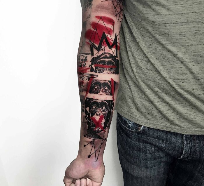 Close-up of a vibrant Trash Polka tattoo on a person's forearm with abstract red and black elements.