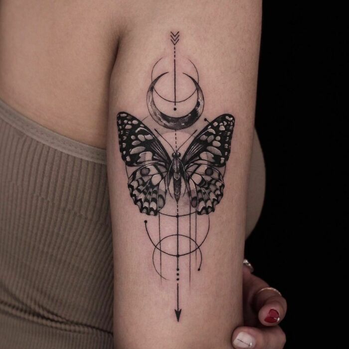 geometrical butterfly and moon arm tattoo