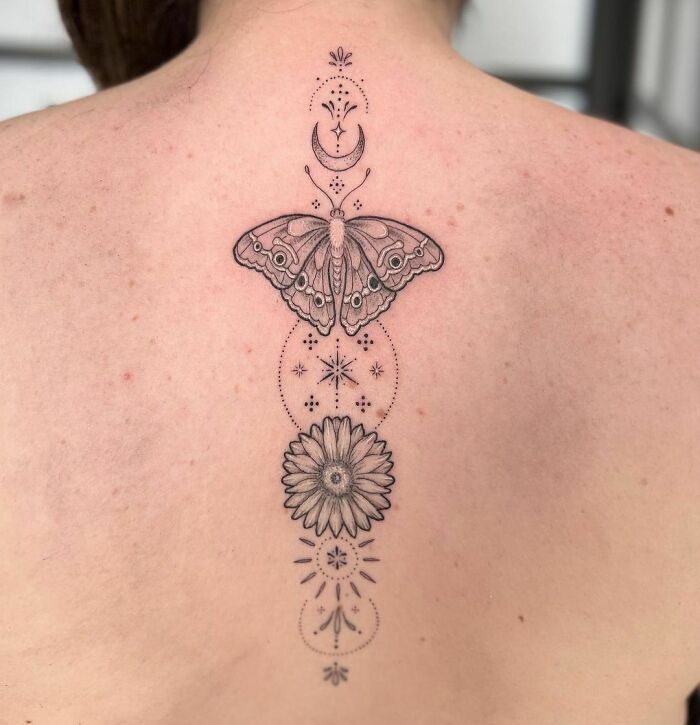 Butterfly tattoo with geometrical shapes along the spine tattoo