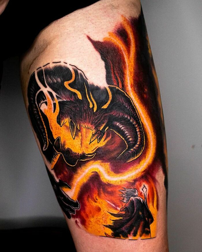 Balrog tattoo from Lord of the Rings on arm, featuring vivid flames and dark shadows, symbolizing epic fantasy art.