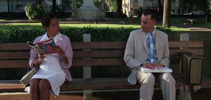 Forrest Gump looking at the woman on the bench in the park
