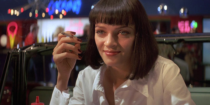 Mia Wallace smiling with cigarette in her hand
