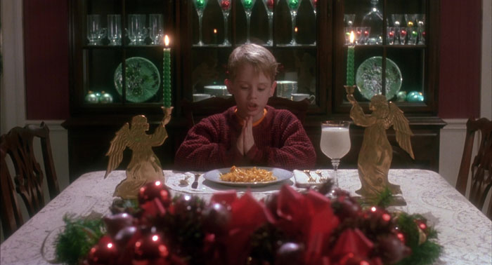 Kevin praying near the plate with food