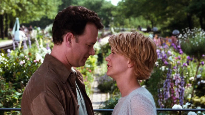 Joe Fox and Kathleen Kelly looking at each other in the garden