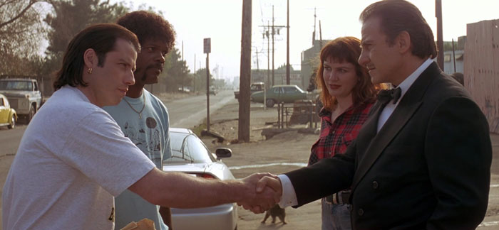 Vincent Vega shaking hand to the Wolf in the street while Mia and Jules staying nearby