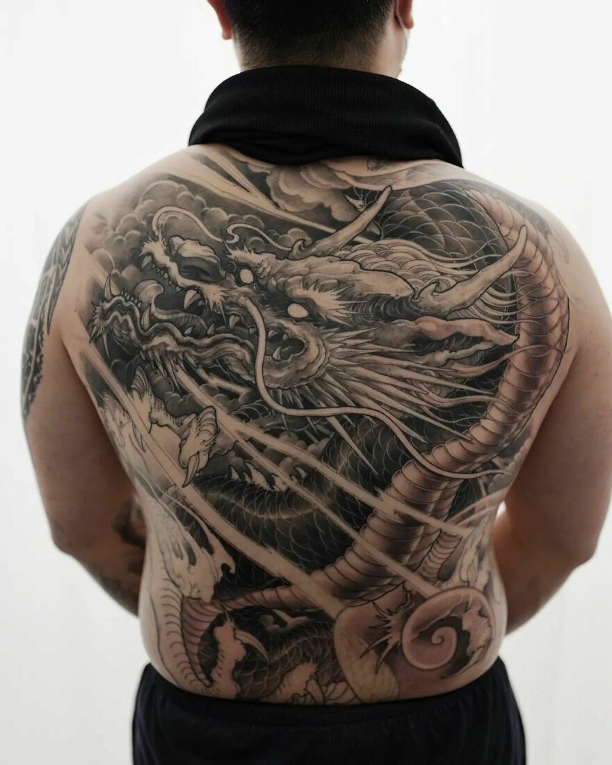 the back of a man with a dragon tattoo