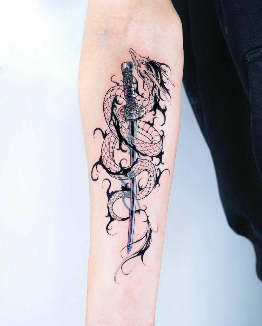 A Forearm tattoo of a dragon wrapped around a katana