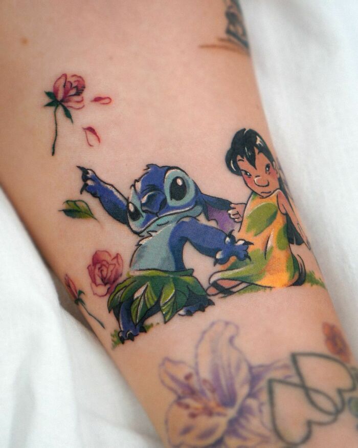 Colorful pop culture tattoo featuring animated characters surrounded by flowers.