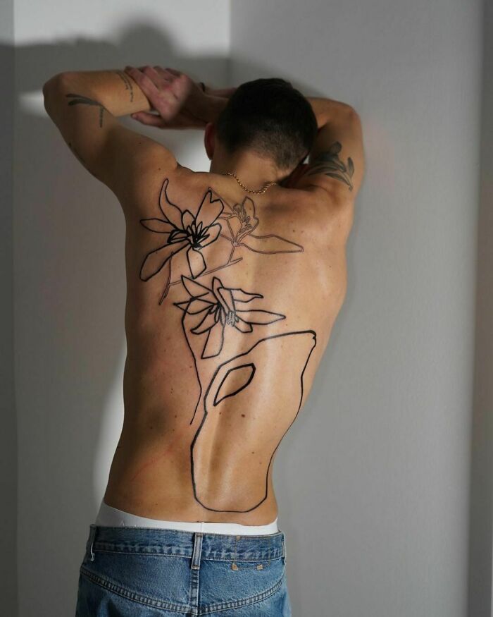 Tattoo artist's viral back piece with abstract floral design and bold lines, drawing widespread attention online. Tattoo artist's viral back piece with abstract floral design and bold lines, drawing widespread attention online.