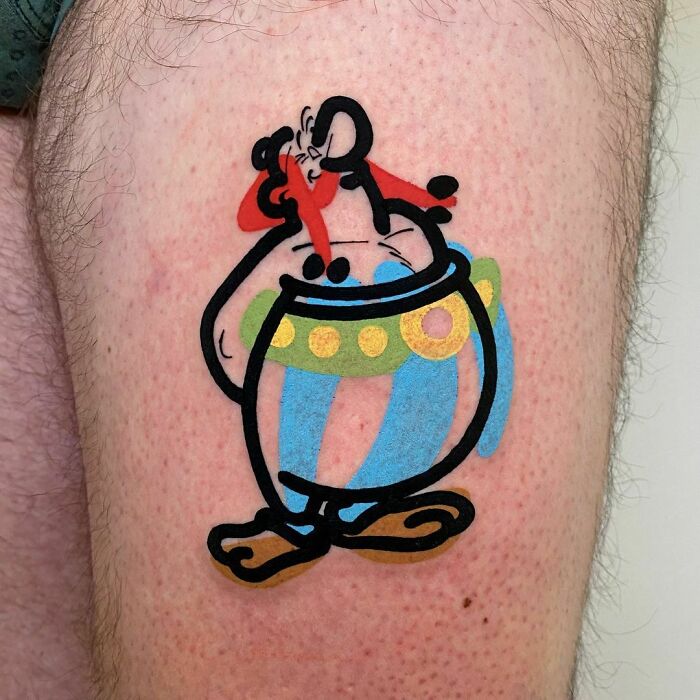 Pop culture tattoo featuring a cartoon character with a red hat and blue pants on a person's skin.