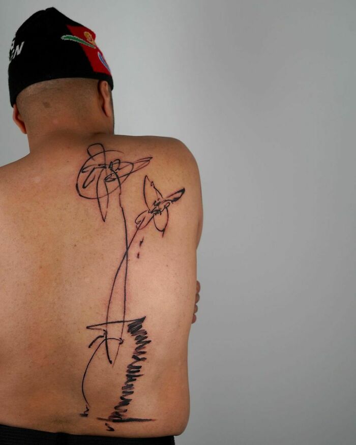Tattoo artist's abstract back piece in viral image, sparking online discussion. Tattoo artist's abstract back piece in viral image, sparking online discussion.