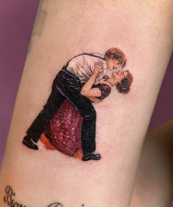 Pop culture tattoo of a couple dancing in vintage attire, inked beautifully on the skin.